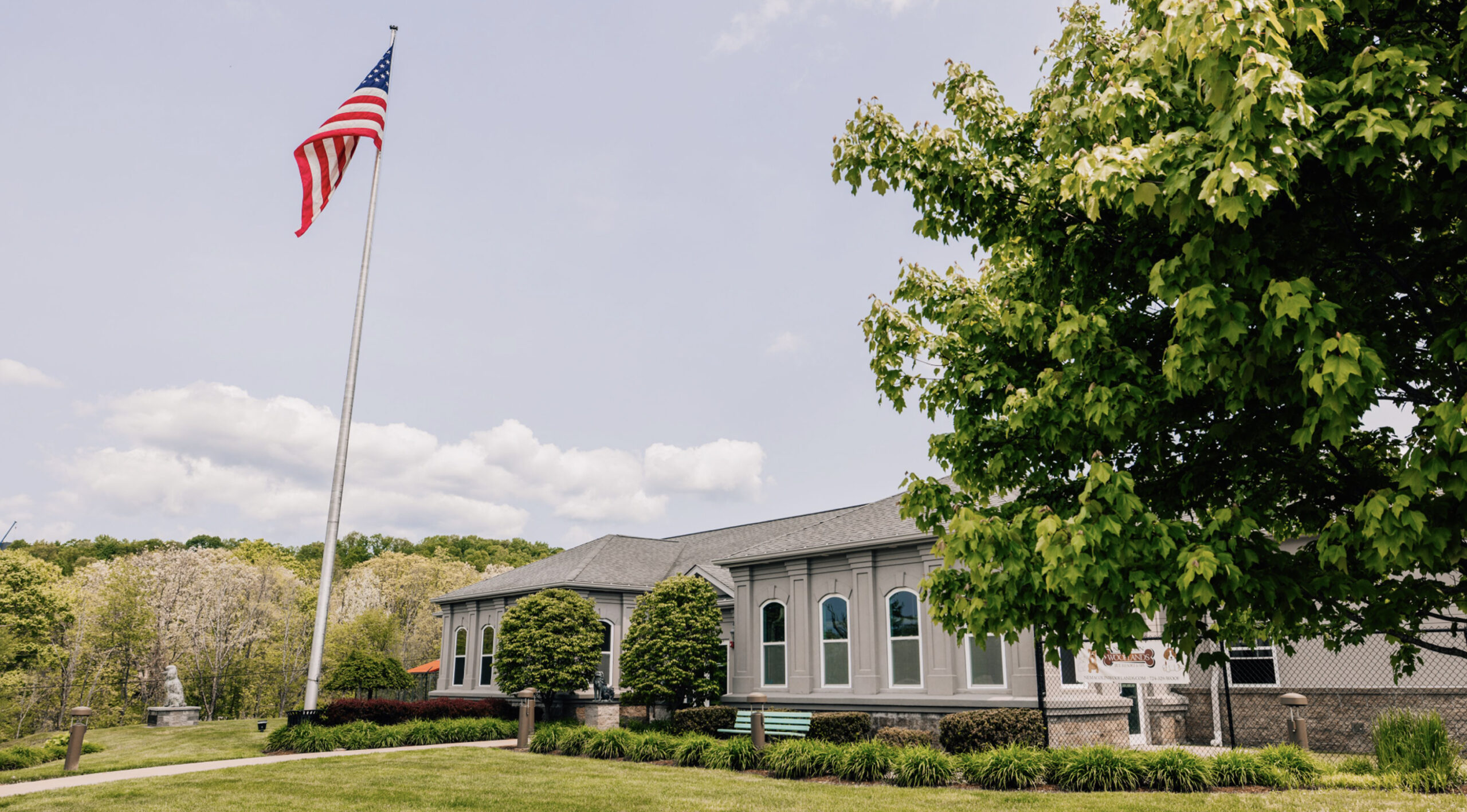 This image depicts the outside of a building and an American flag on a sunny day.