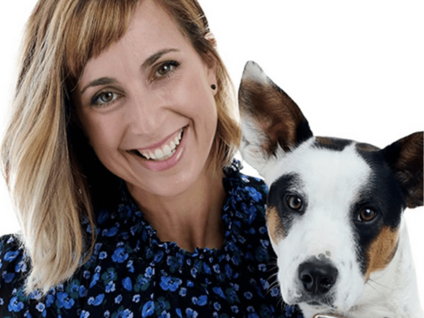 This image depicts a black white and brown dog's face next to a smiling woman's face.